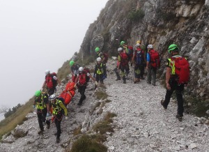 I tecnici del Soccorso Alpino riportano a valle la salma seguiti dalla comitiva di amici della persona deceduta